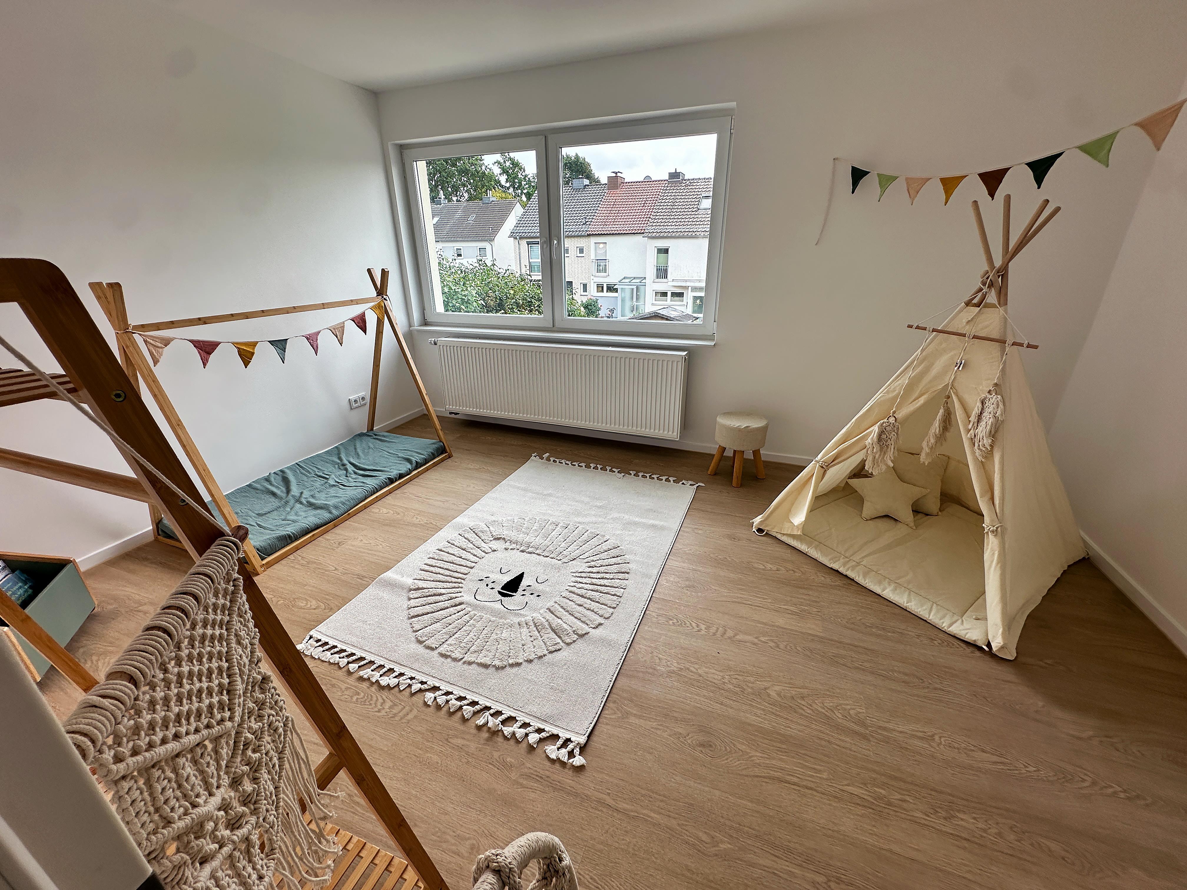 Als Kinderzimmer eingerichteter Raum im Reihenhaus, mit modernem Vinylboden und Blick in die Nachbarschaft